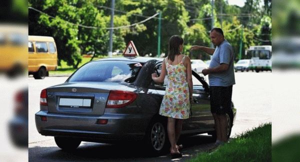 Люди возле учебного автомобиля.